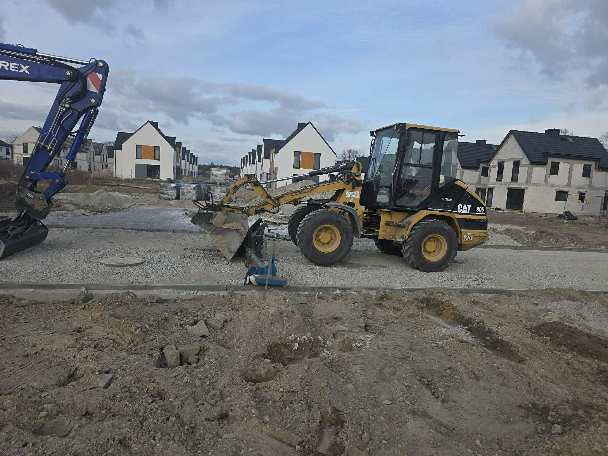 Ładowarka CAT 906 przy pracach drogowych i podbudowie – okolice Długołęki