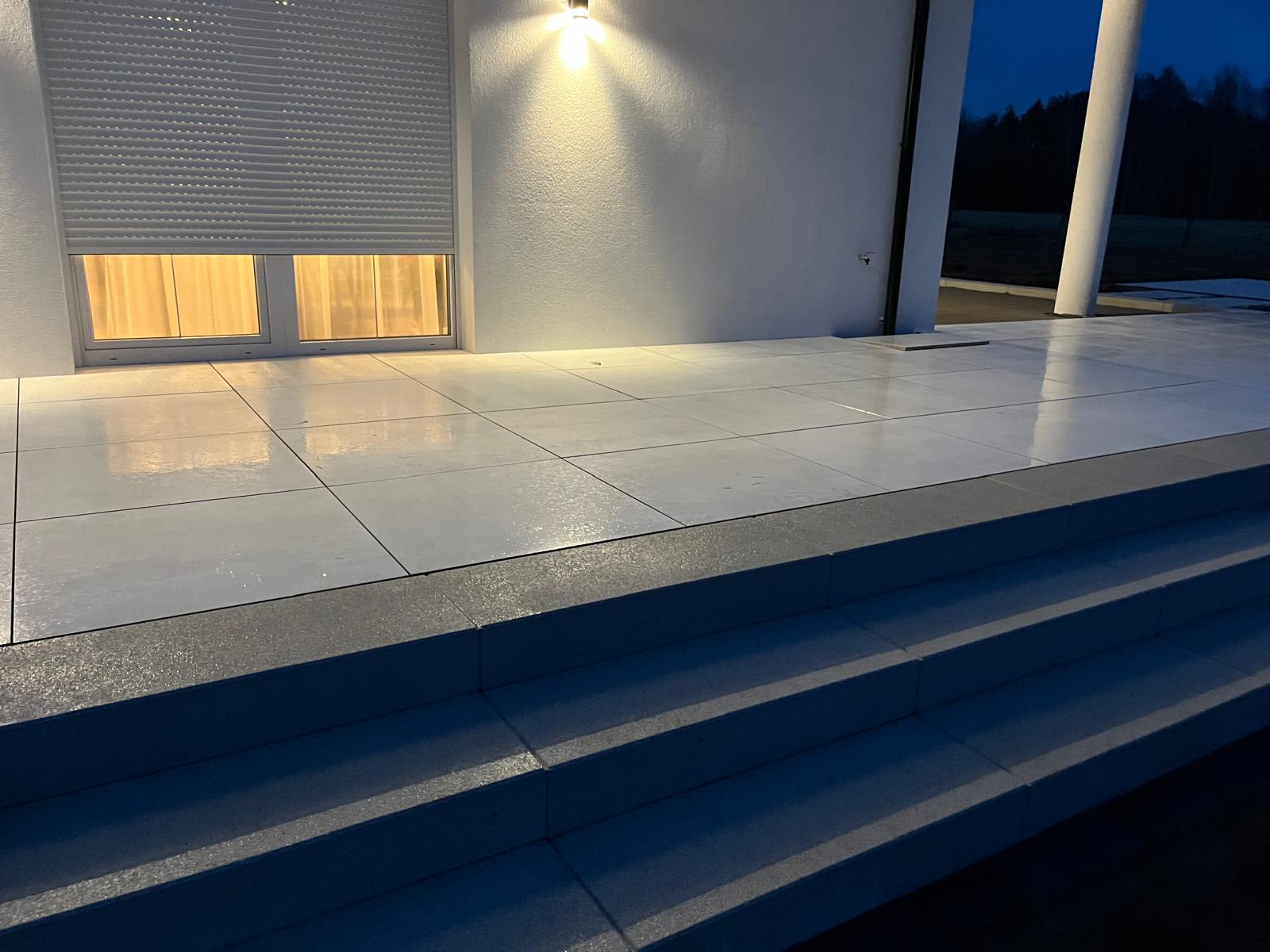 Taras z jasnych płyt granitowych – zdjęcie wieczorne, realizacja brukarstwo Długołęka
